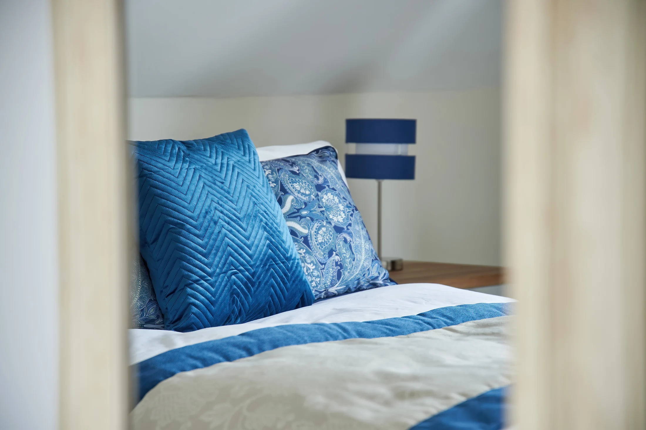 Blue and white bedding prepared in a private bedroom at Nettlestead Care Home