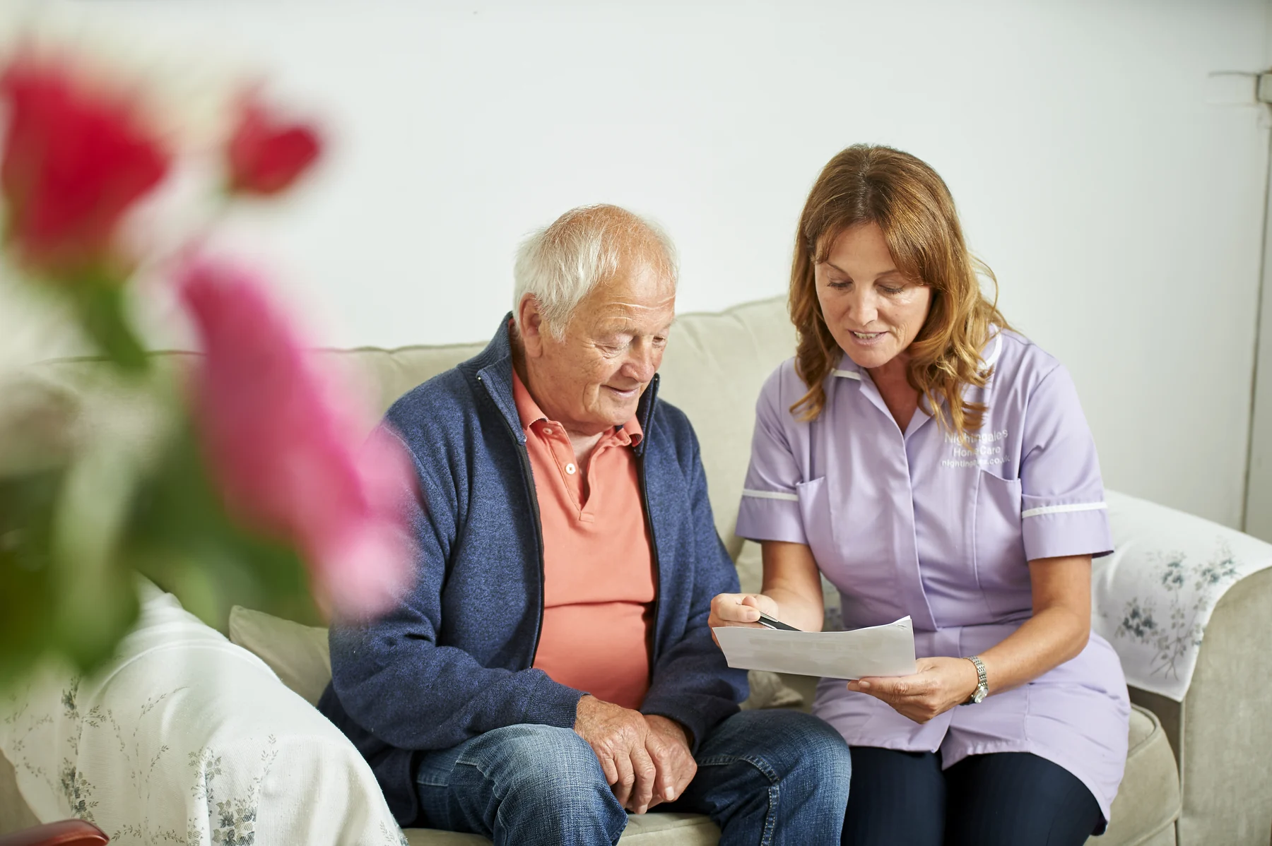 An older man reviewing care information with a care professional
