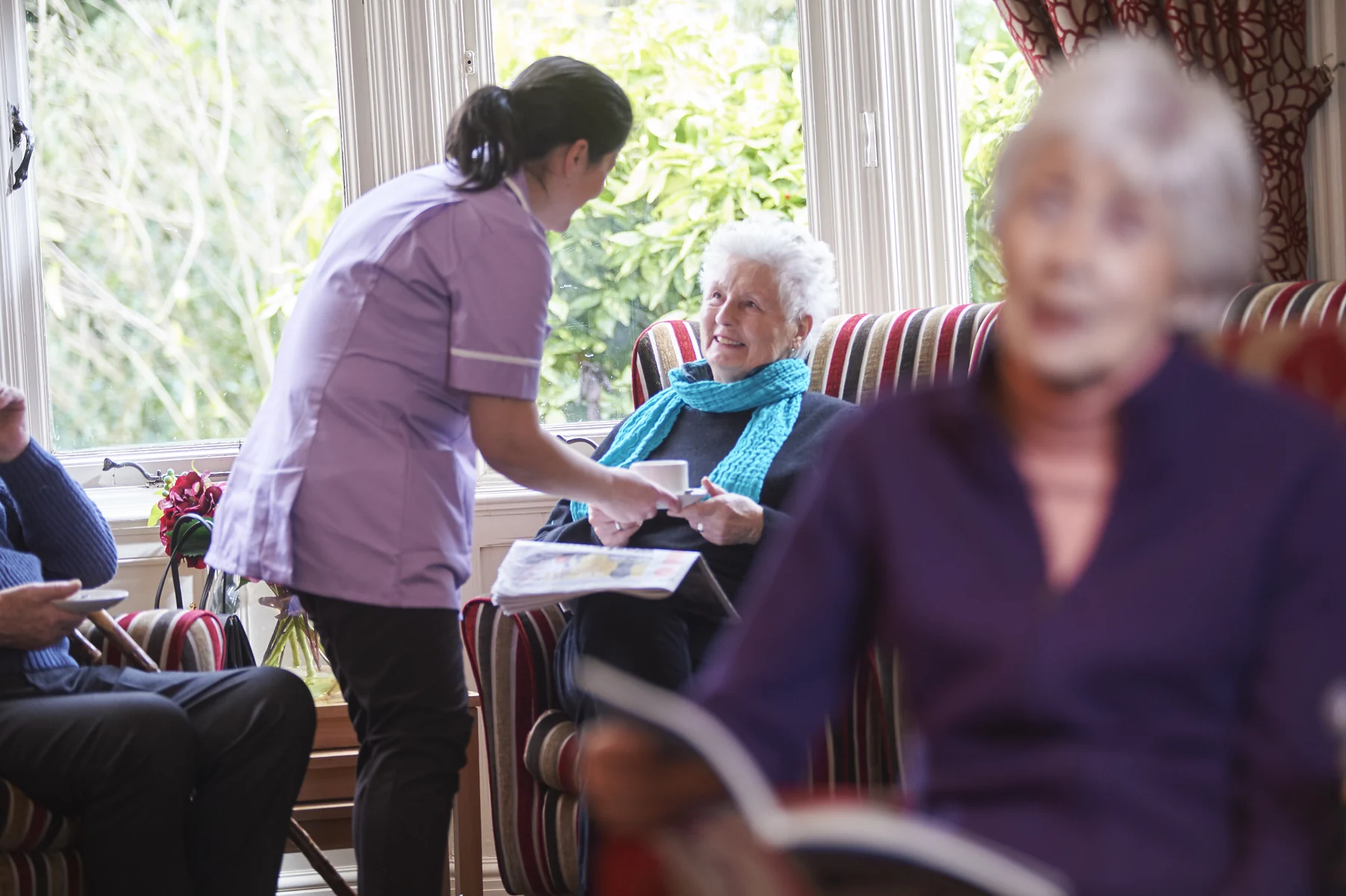 A member of the care team spending time with a resident in a Nettlestead lounge