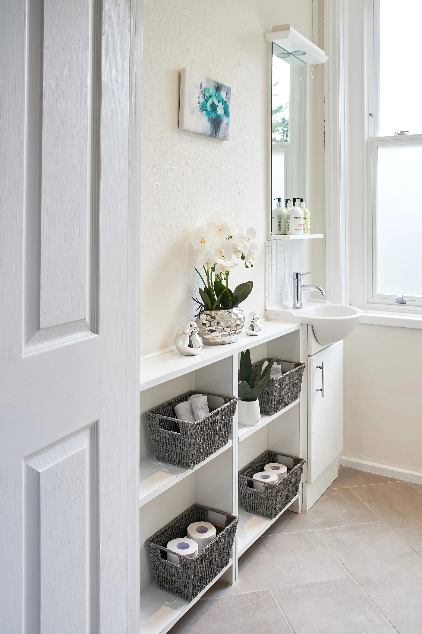 A bright ensuite wash area with flowers and neatly arranged towels at Nettlestead