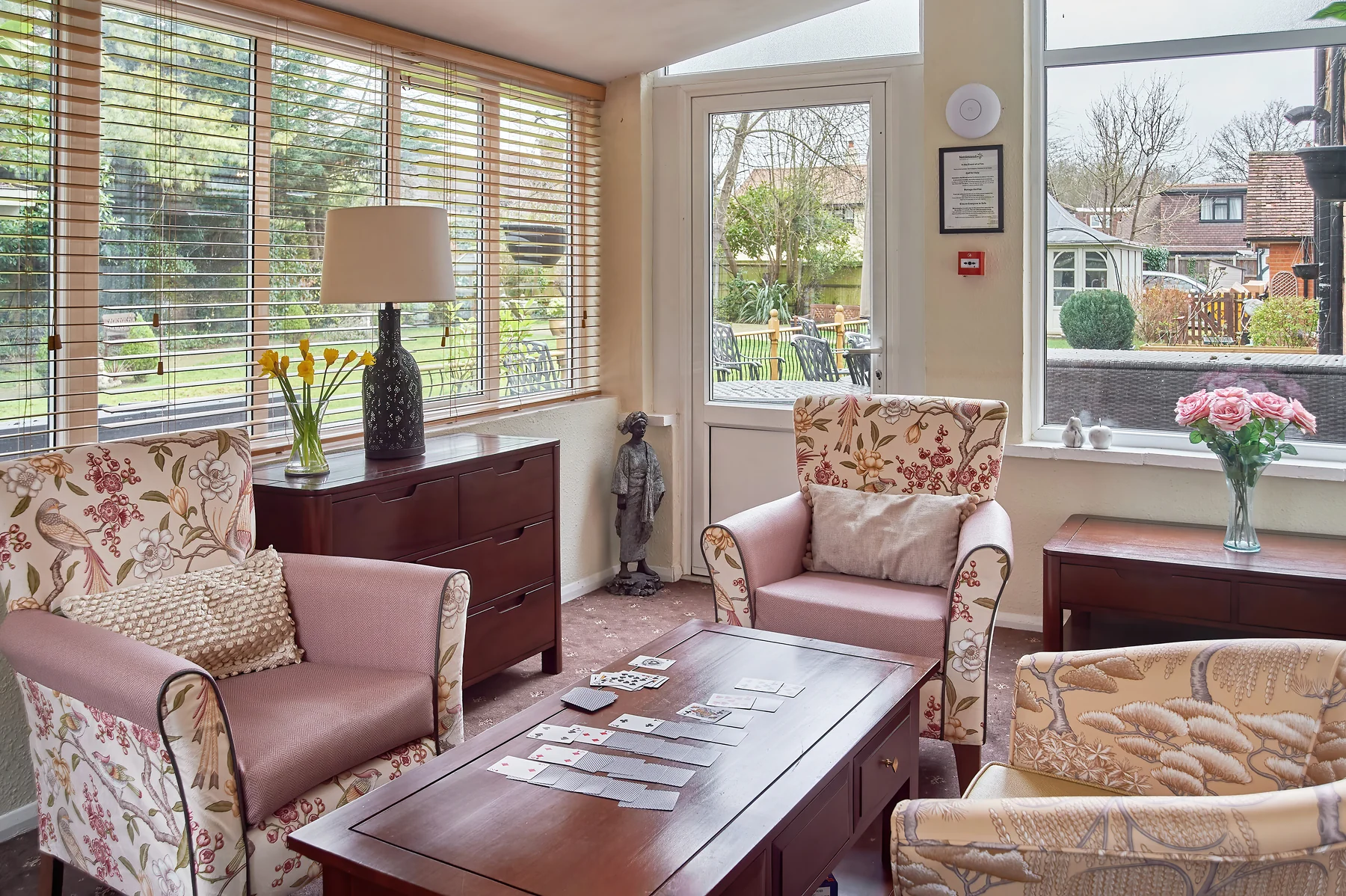 A bright pink lounge with comfortable chairs and views into the Nettlestead garden