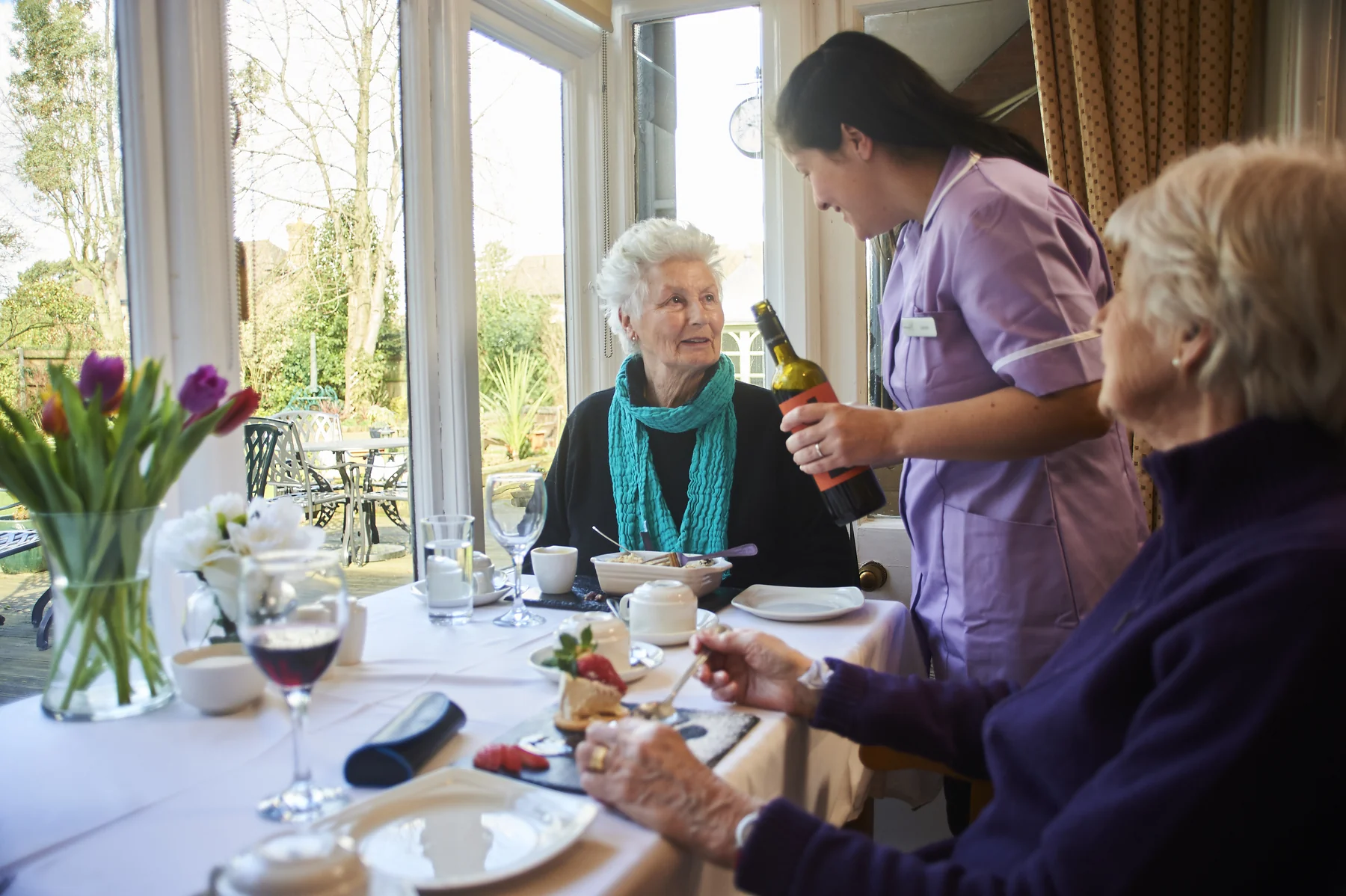 Two Nettlestead residents sharing a relaxed meal with a member of the care team