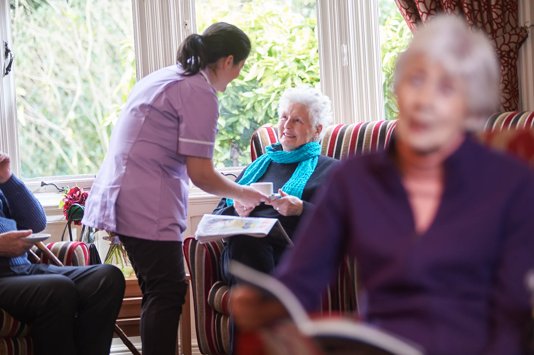 A care professional spending time with a resident in a shared lounge